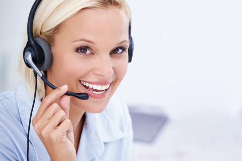 Frau mit Headset lacht in die Kamera