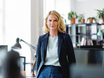 eine Frau im Business-Look schaut in die Kamera