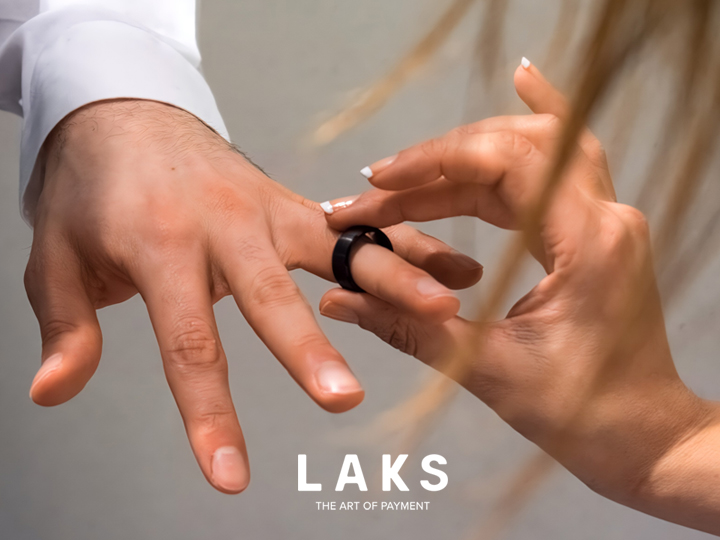 ein Mann bekommt einen schwarzen LAKS Pay-Ring an den Finger gesteckt