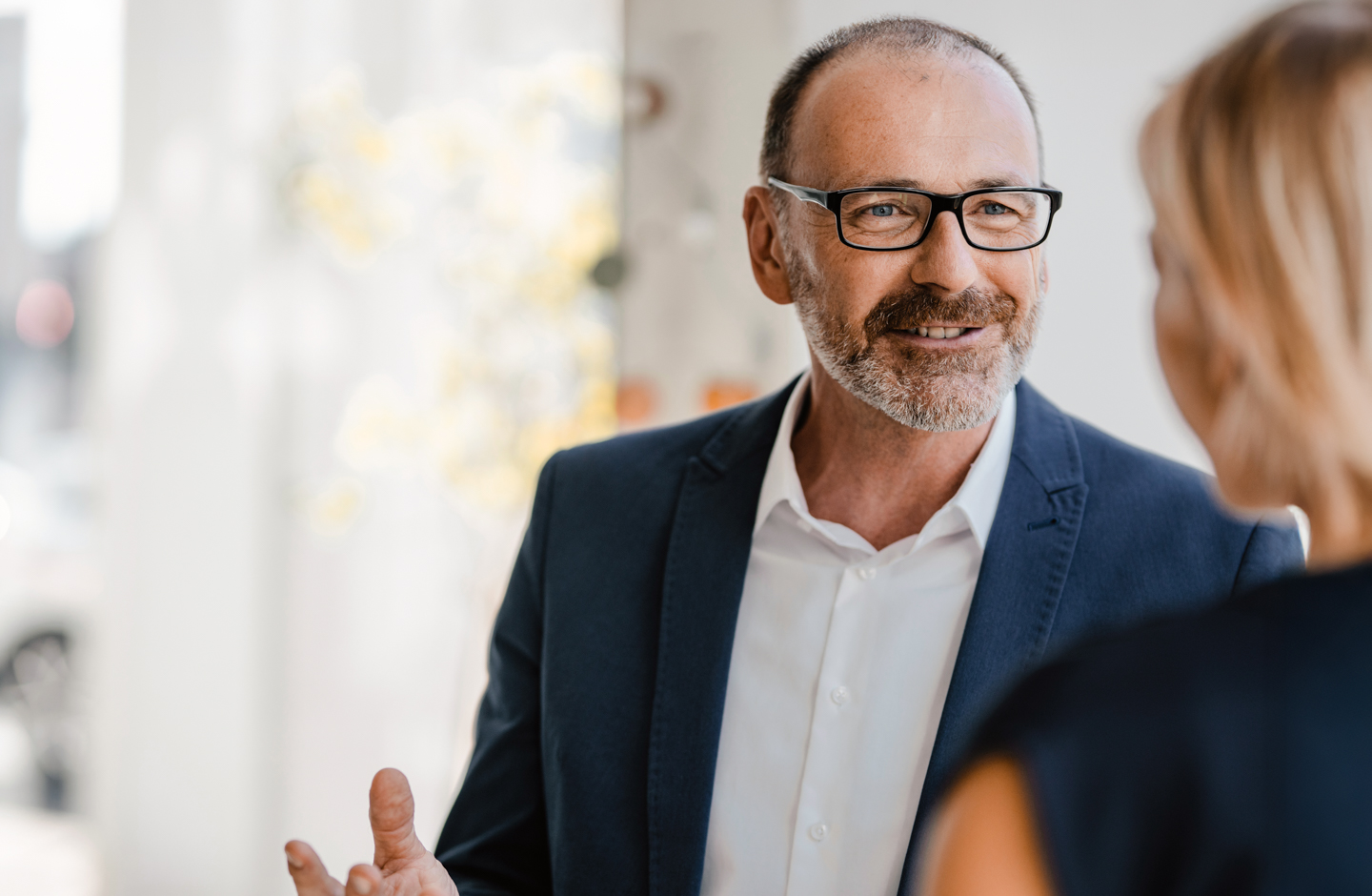 ein Mann mit Brille spricht  mit einer Frau