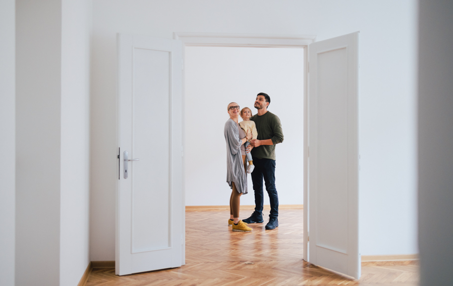 eine junge Familie steht in einer leeren Wohnung